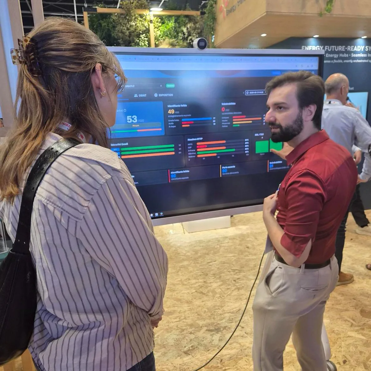 VivaTech 2026 - walking a visitor through a live Cyber Monitor OSINT exposure report on the booth